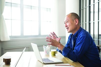 Man-sitting-at-desk-with-laptop