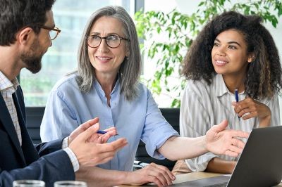 Three-people-discussing-financial-plan-at-boardroom-meeting.